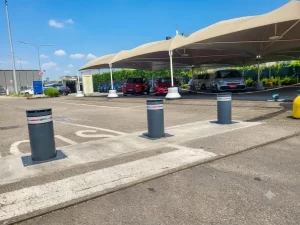 Nell'immagine si vede una esposizione esterna di autovetture con un ingresso protetto da dissuasori blindati a scomparsa.