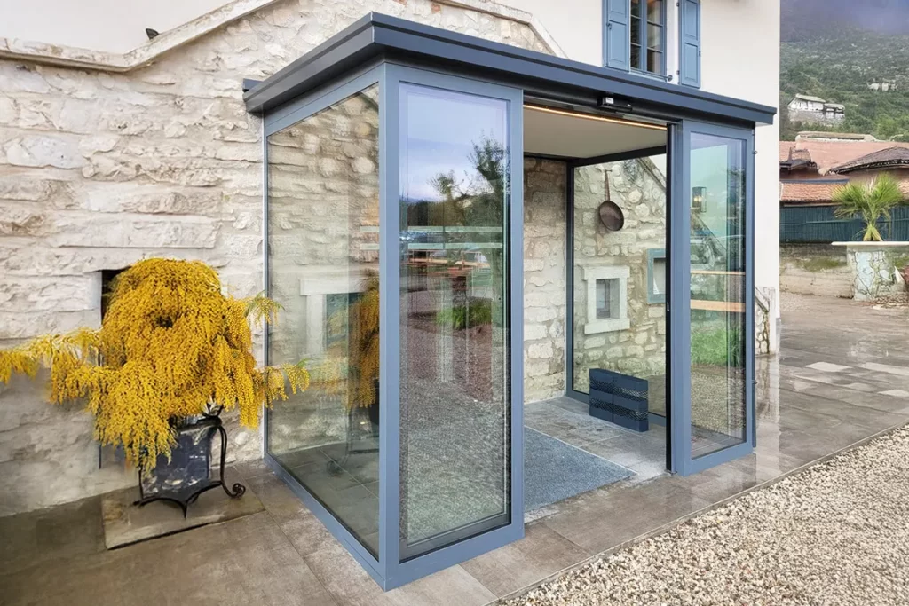 L'ingresso di questo ristorante è stato completato con una bussola realizzata con una coppia di porte automatiche con due ante mobili e due ante fisse. Ai lati, ampie vetrate per la maggiore trasmissione di luce.