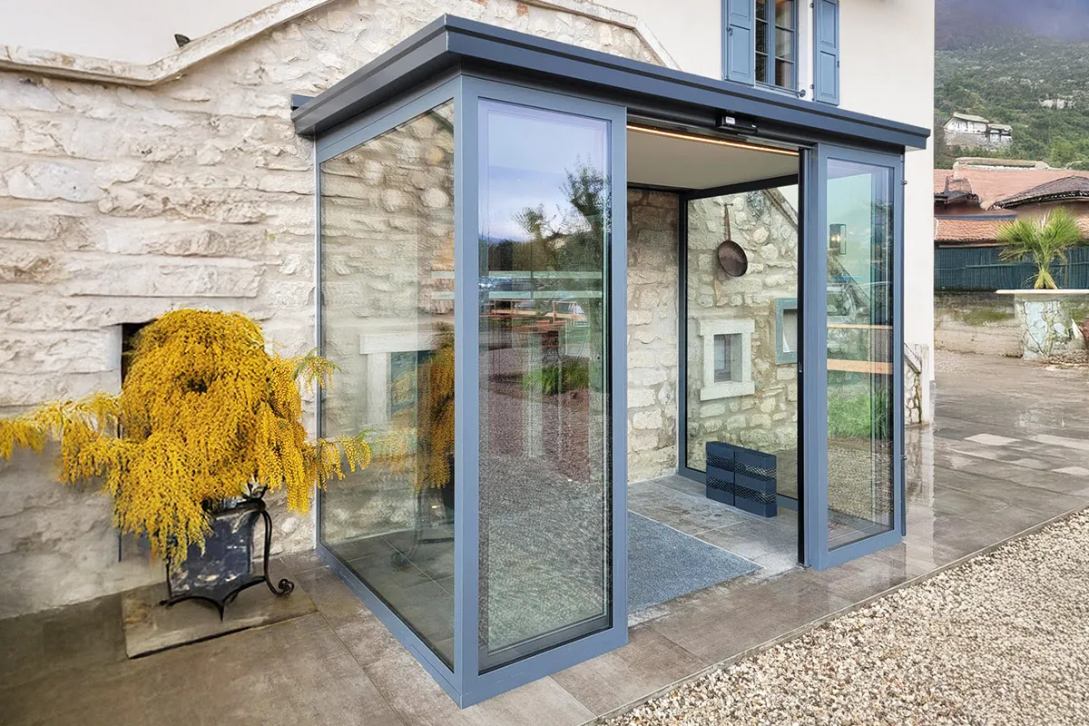 L'ingresso di questo ristorante è stato completato con una bussola realizzata con una coppia di porte automatiche con due ante mobili e due ante fisse. Ai lati, ampie vetrate per la maggiore trasmissione di luce.