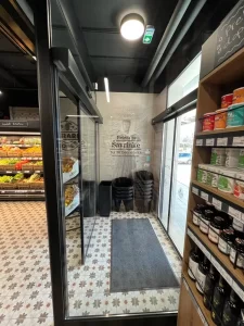 L'ingresso di questo negozio di alimentari è realizzato con una coppia di porte automatiche contrapposte che compongono una bussola.