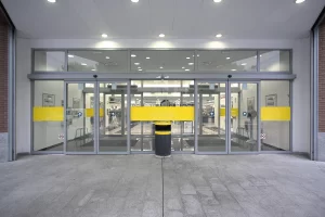Una soluzione tipica negli ipermercati, dove gli ingressi sono realizzati con grandi bussole e con l'impiego di porte automatiche scorrevoli con ante fisse e ante mobili, tutte con sistemi di sfondamento totale antipanico.