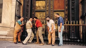 Nell'immagine si vedono i 5 tecnici IMER che, nel 1985, stanno lavorando per automatizzare uno dei 3 cancelli ad alzata verticale che proteggono le porte del Battistero di Firenze.Sono Berto, Maurizio, Riccardo, Sergio e Mario: professionisti che misero la loro esperienza al servizio di un progetto destinato a diventare parte integrante della gestione quotidiana del Battistero.