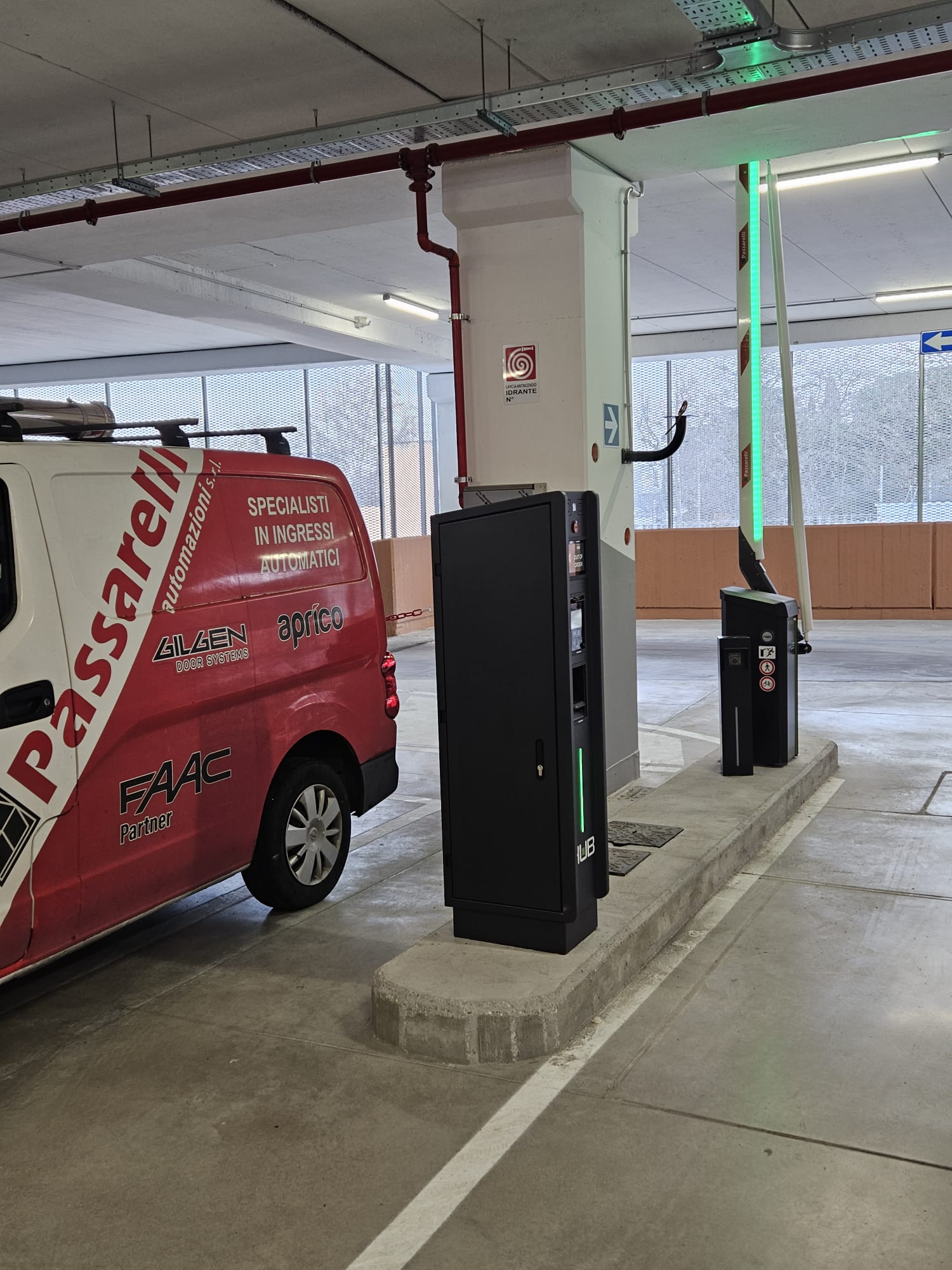 Nell'immagine si vede l'uscita da un parcheggio sotterraneo di un edificio commerciale. L'uscita è gestita da una barriera automatica comandata da un biglietto che viene validato prima dell'uscita e che viene inserito nell'apposito lettore.