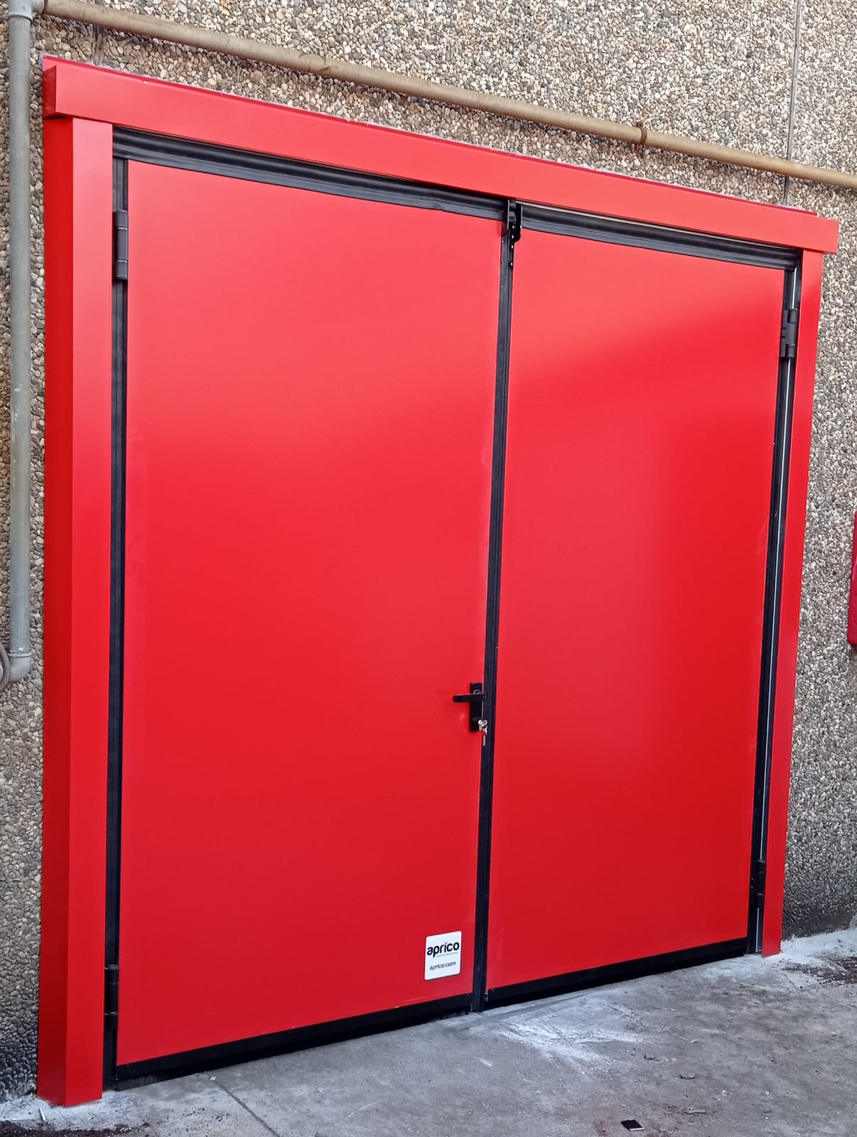 Nell'immagine si vedono porte tagliafuoco a due ante battenti, installato come uscita di emergenza dal magazzino di un'azienda artigianale.