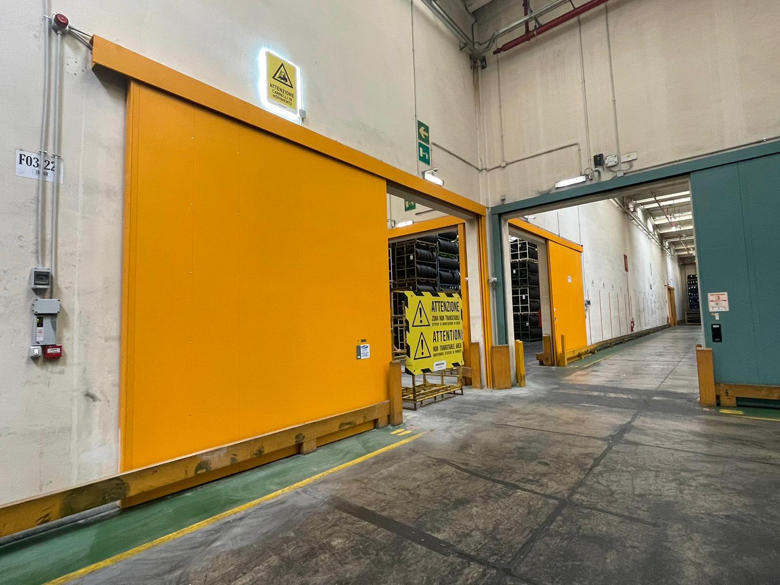 nell'immagine si vedono ben quattro porte scorrevoli tagliafuoco di grandi dimensioni che possono fare una divisione tra le 4 aree di un grande magazzino industriale.