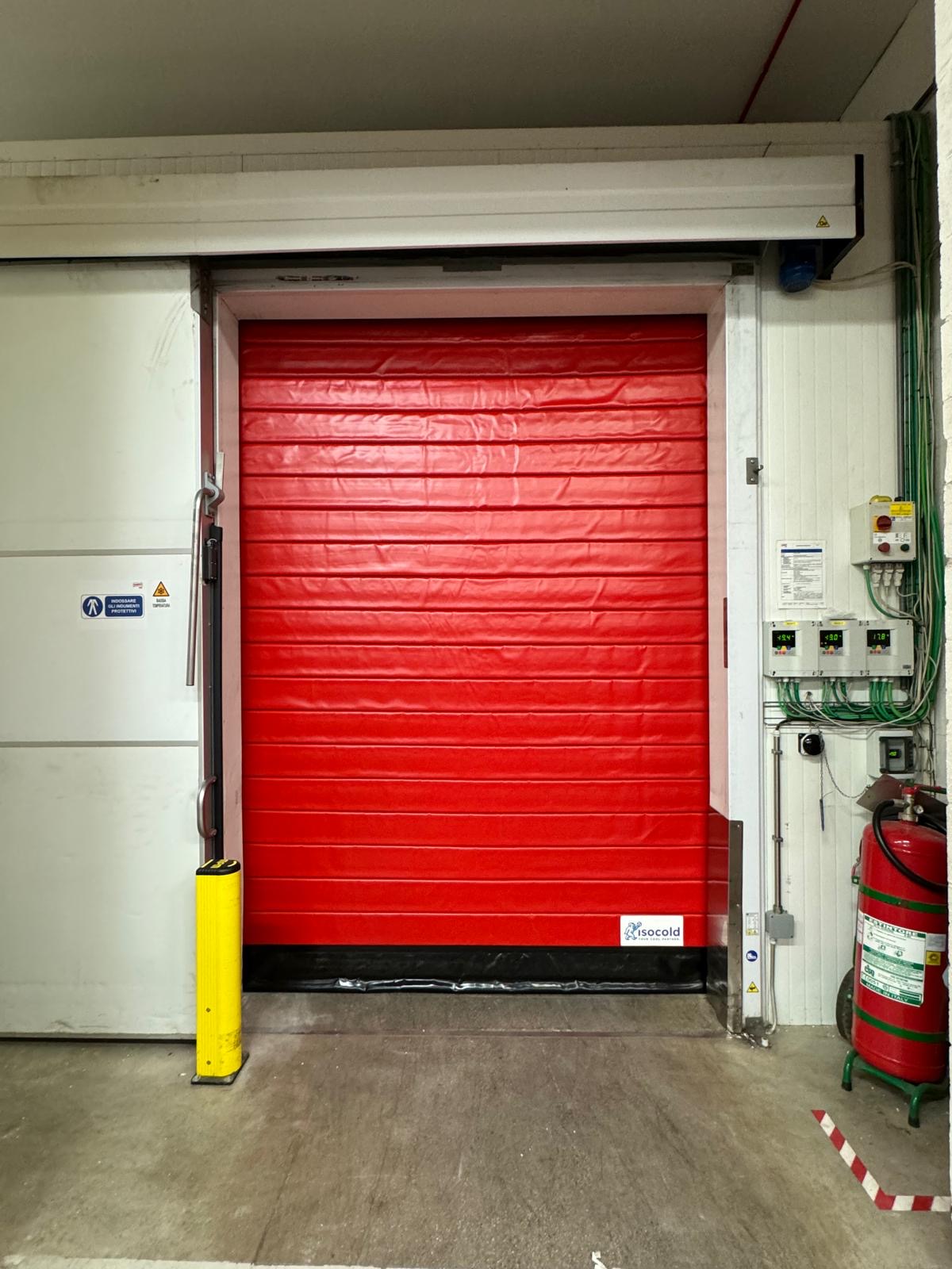 paracolpi giallo installato vicino a una porta rapida di colore rosso
