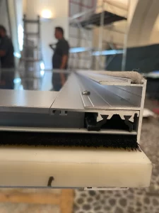 Dettagli del profilo in PVC e delle guarnizioni ad F con spazzolini per limitare il passaggio dell'aria.