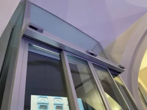 Bussola con porta automatica all’ingresso di Palazzo Trentini. Dettaglio del sopraluce incassato nel soffitto a volta e dell'automazione ridondante.