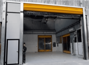 porta rapida industriale su misura con portone a libro integrato e tecnico Aprico vicino al montante verticale della porta