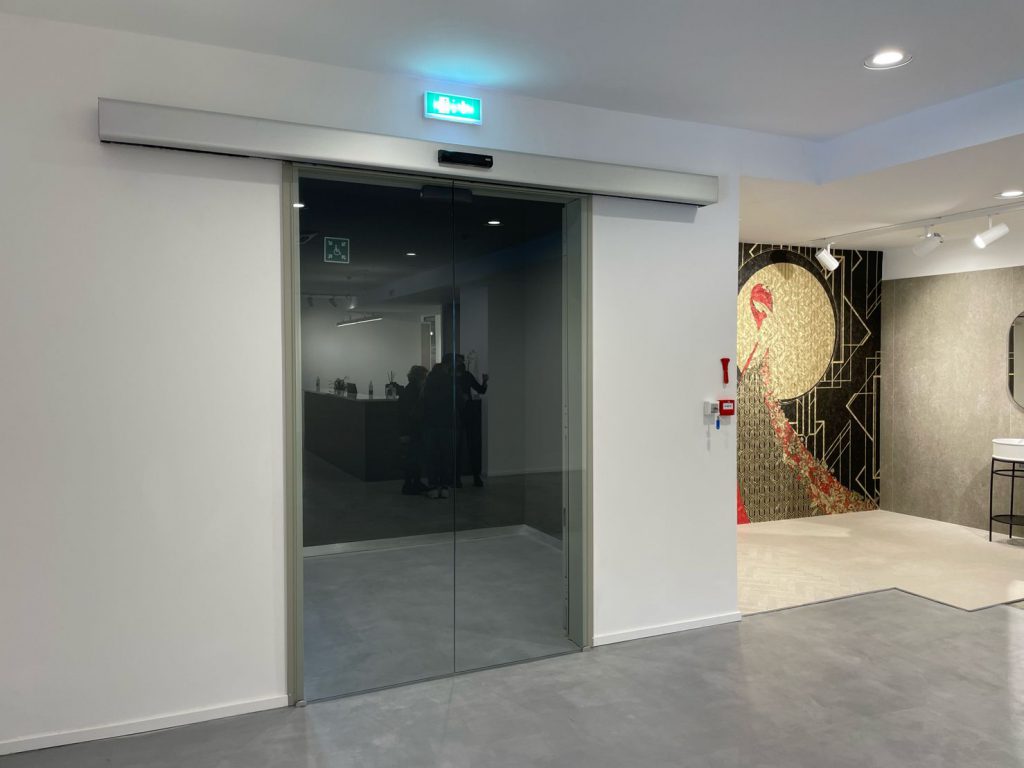 Porte automatiche scorrevoli ridondanti con ante in vetro temperato.