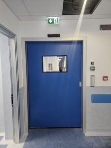 porta automatica scorrevole di colore blu che da accesso nella camera di preparazione della sala operatoria