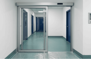 Porta automatica con anta fissa più anta mobile installata all'ingresso del reparto. Serramento sottile. Ante tutto vetro. radar di attivazione apertura e chiusura.