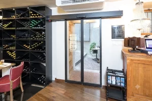 Nell'immagine si vede l'ingresso di un bar ristorante gestito da una porta automatica scorrevole con due ante mobili.