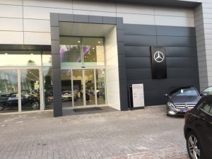 Nell'immagine si vede l'ingresso di una porta automatica scorrevole di una concessionaria Mercedes.