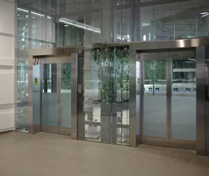 Ingresso di un'azienda di alta moda con doppia porta automatica e serramenti in acciaio inox