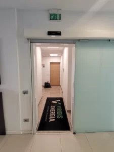 Porta automatica scorrevole in vetro satinato all'ingresso di uffici aziendali