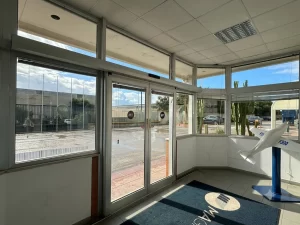 Porta automatica scorrevole a due ante con automazione ridondante in una reception aziendale