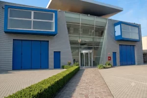 Edificio industriale con ingresso aziendale curvilineo e portoni a libro per i reparti produttivi