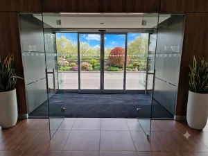 Un ingresso elegante di una show room di autovetture realizzato con una bussola dotata di porta automatica scorrevole con due ante fisse e due ante mobili.