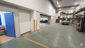 interno di un magazzino con porte sezionali bianche che dividono l'area del magazzino aziendale dall'area dedicata al garage privato del proprietario.
