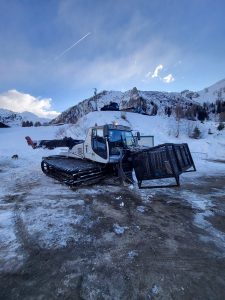 Nella foto si vede un gatto delle nevi con un grande cestino montato sulla parte anteriore, usato per trasportare sulla neve e sino all'hotel, i materiali necessari per montare le porte automatiche, le vetrate e le porte tagliafuoco. Nel cestino ci sono i serramenti necessari per montare le vetrate tagliafuoco dell'hotel.