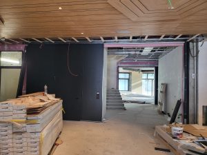 nell'immagine si vede una grande porta scorrevole tagliafuoco montata all'interno dell'hotel. Sul pavimento sono sparsi i materiali ed il parquet necessari per la ristrutturazione dei locali.