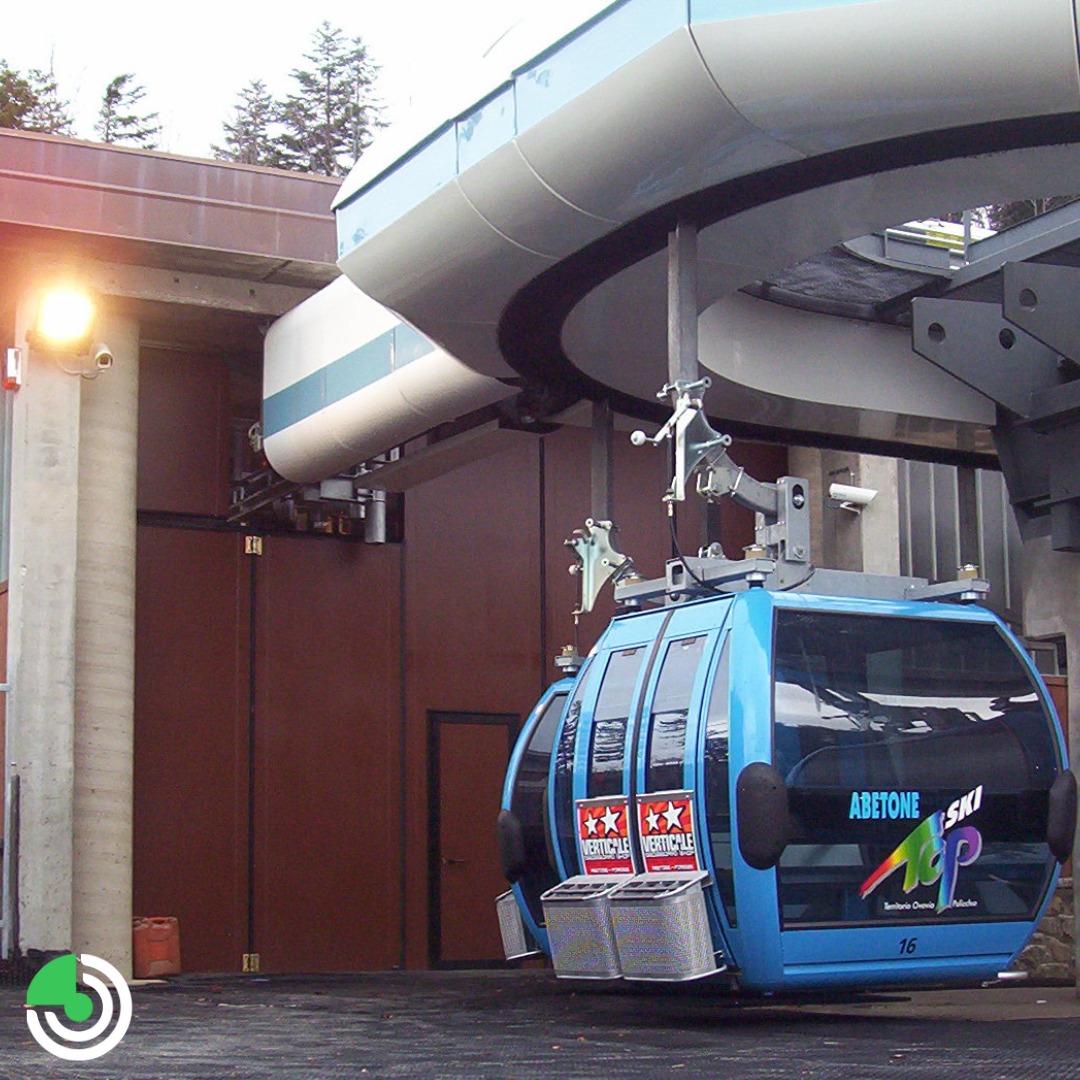 Portone a libro ad impacchettamento laterale color rame, realizzato nella stazione di arrivo di una funivia