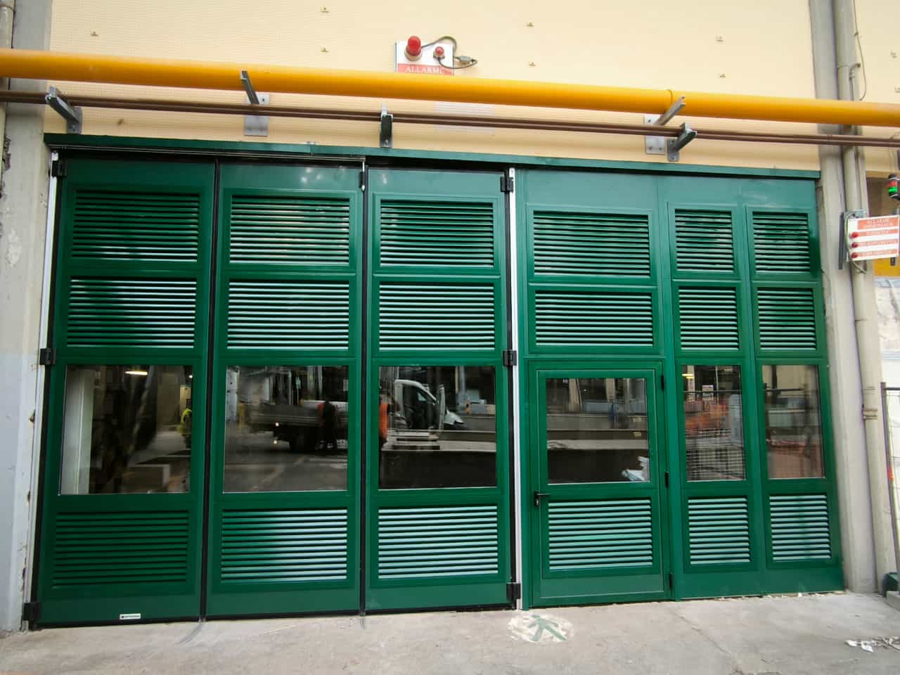portoni a libro: esempio di portone con pannelli dotati di lamelle orizzontali per l'aerazione dei locali