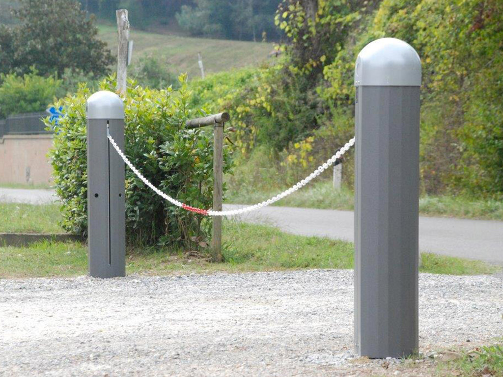 Nell'immagine si vede una strada privata sterrata di accesso ad una proprietà. Per gestire gli ingressi alle persone ed ai veicoli autorizzati sono state installate due colonnine che gestiscono una catena bianca e rossa che si alza e si abbassa comandata da telecomandi radio.